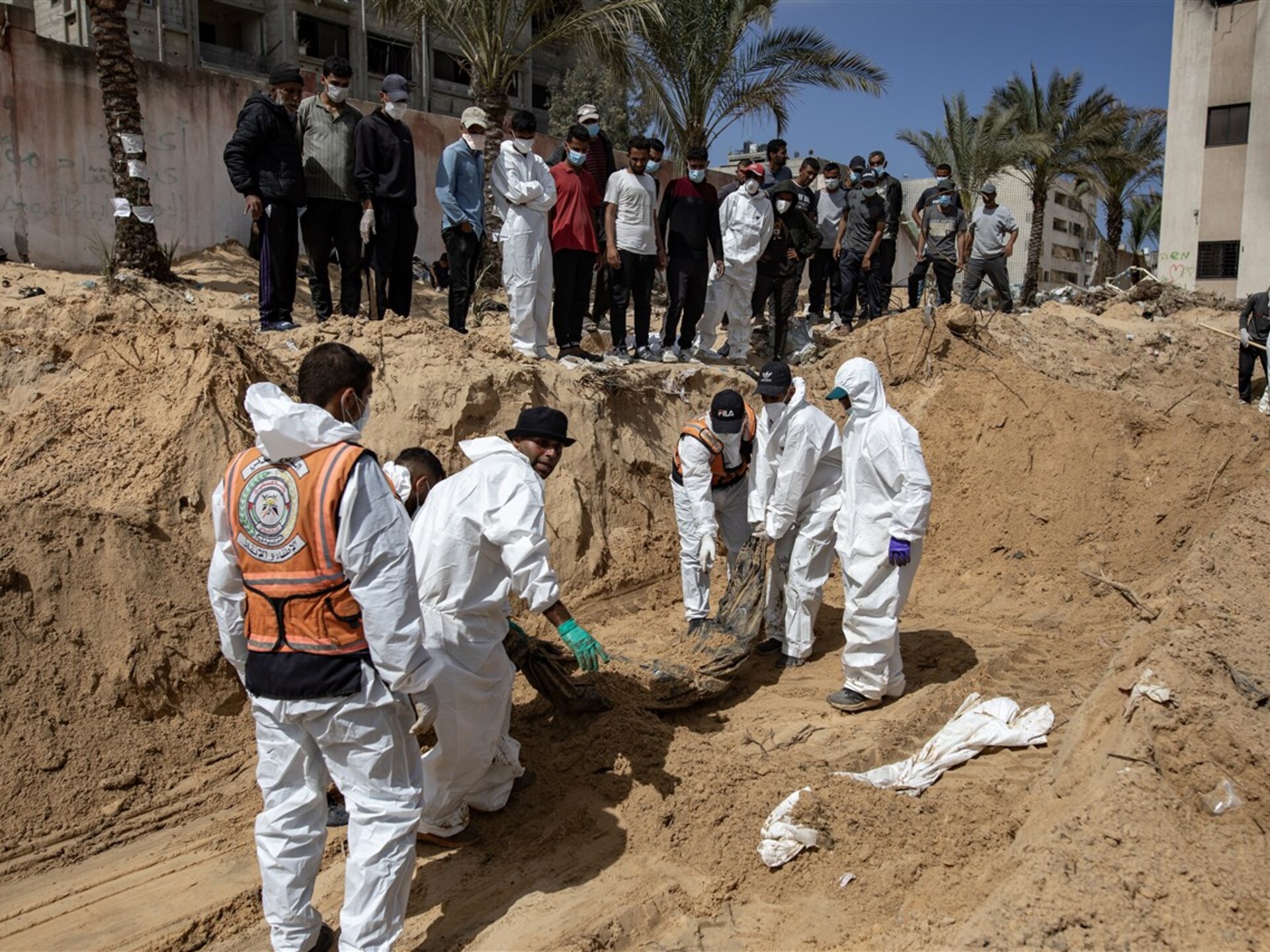 Operatori recuperano resti umani da un sito distrutto nella Striscia di Gaza