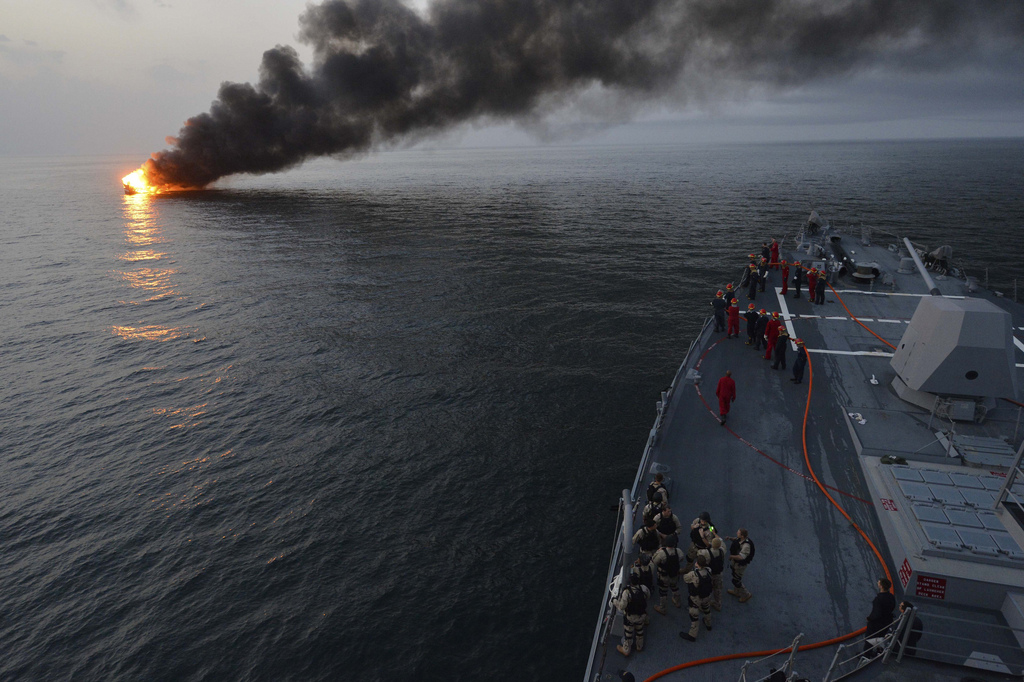 Nave e fumo nello Stretto di Hormuz durante la crisi nel Golfo Persico